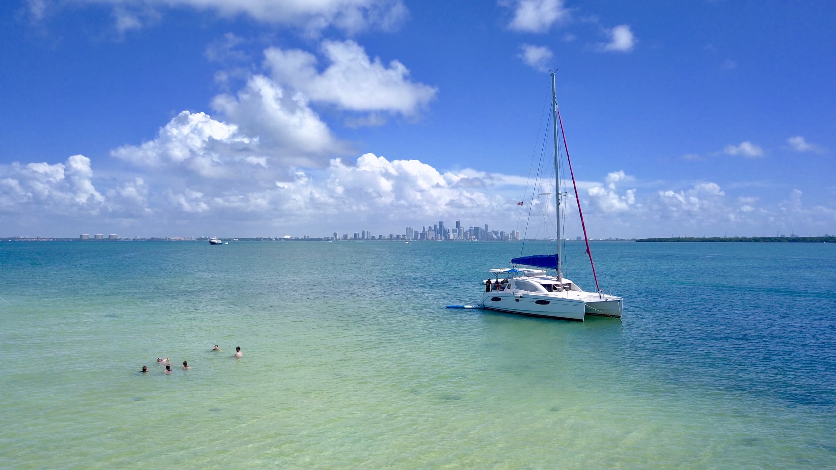 Catamaran anchored in turquoise water with Miami skyline
